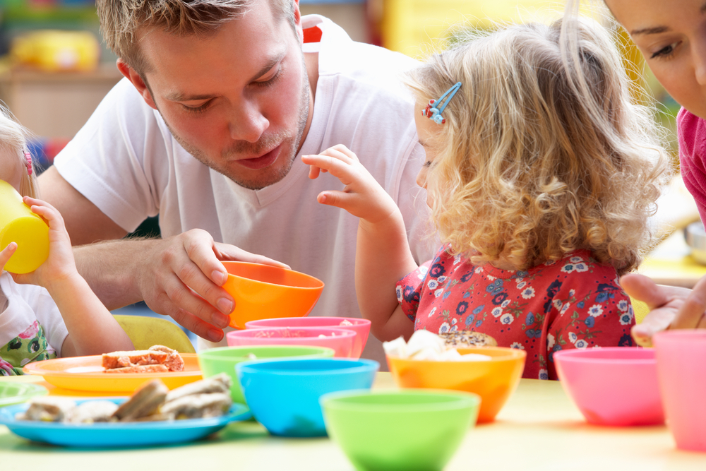 Educateur avec une jeune fille en préparation de repas