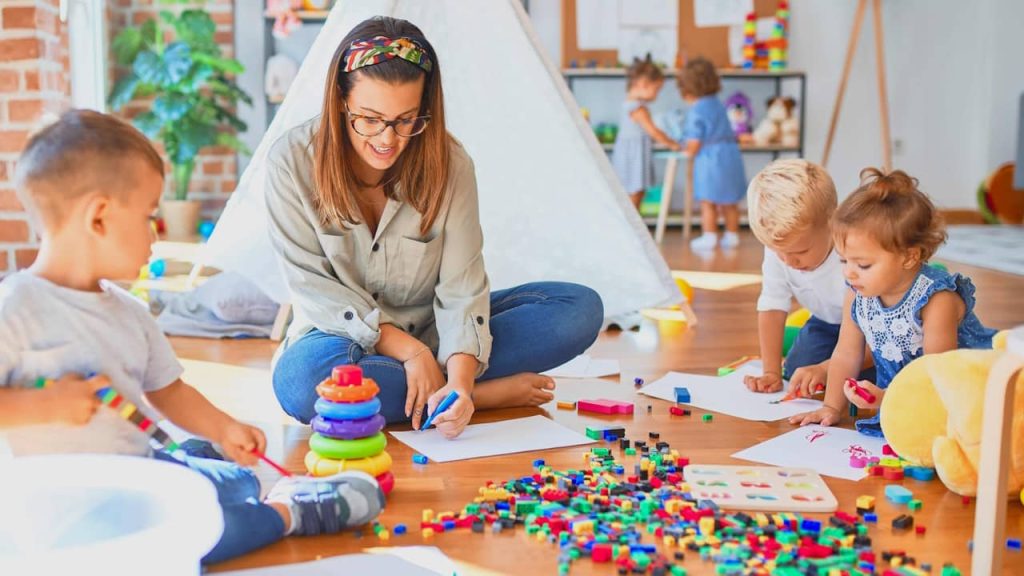 Educatrice entrain de jouer avec des enfants